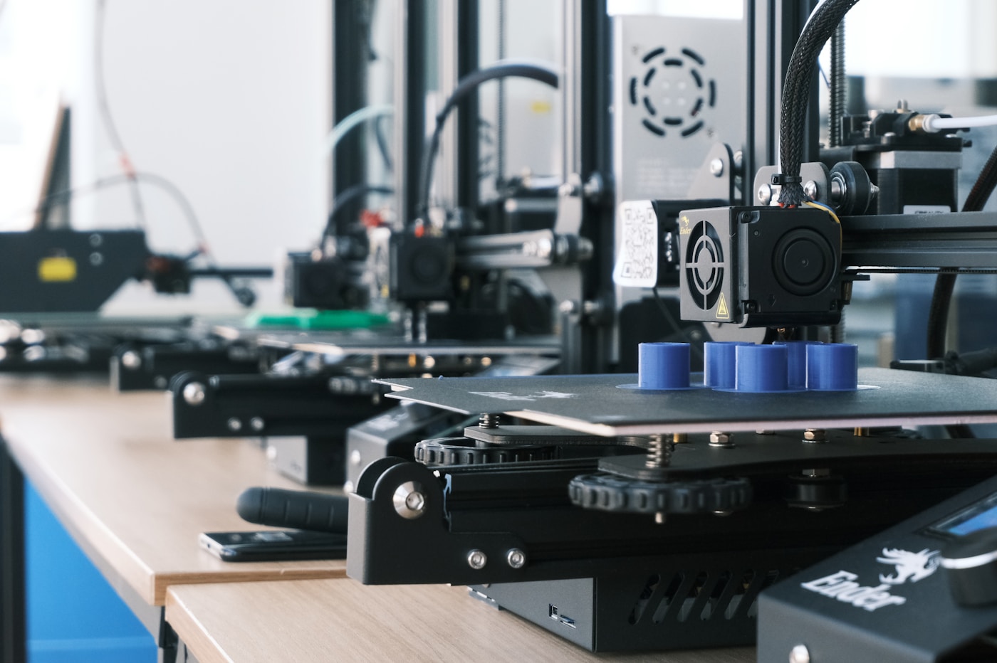 Détail de buse d'impression 3D en train d'extruder du filament dans un atelier artisanal